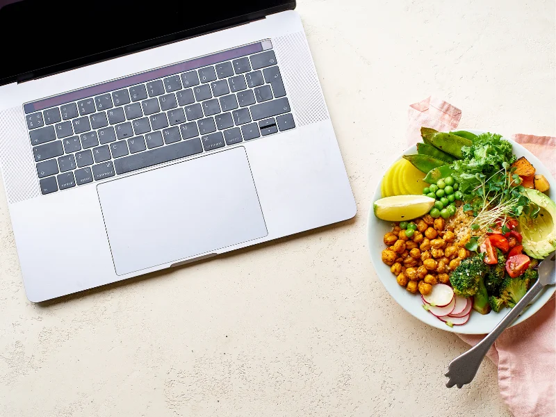 Laptop und ein Teller mit Kichererbsen, Brokkoli und Avocado: Lernen für die Weiterbildung Anti-entzündliche Ernährung